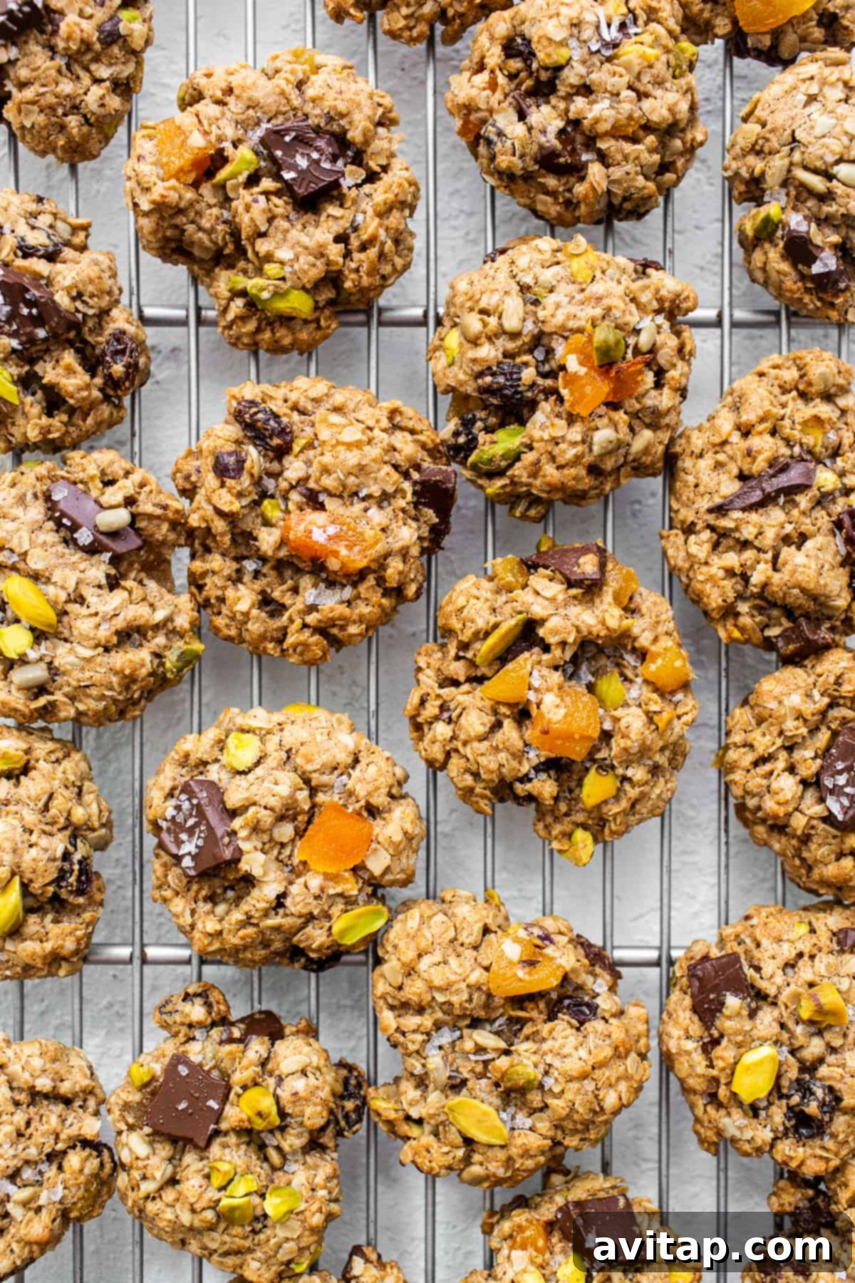 A stack of golden trail mix cookies cooling gracefully on a wire rack, with their delicious mix-ins clearly visible.