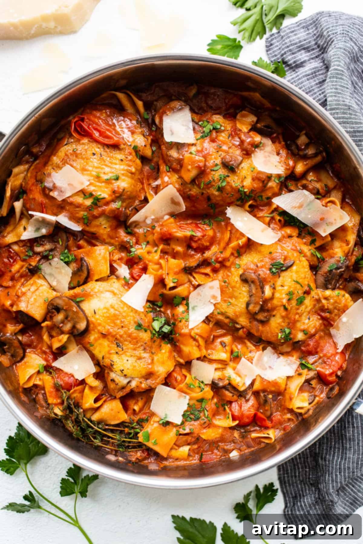 A hearty serving of one-pot pappardelle pasta with chicken thighs in a rustic pot, garnished with fresh herbs and shaved parmesan.