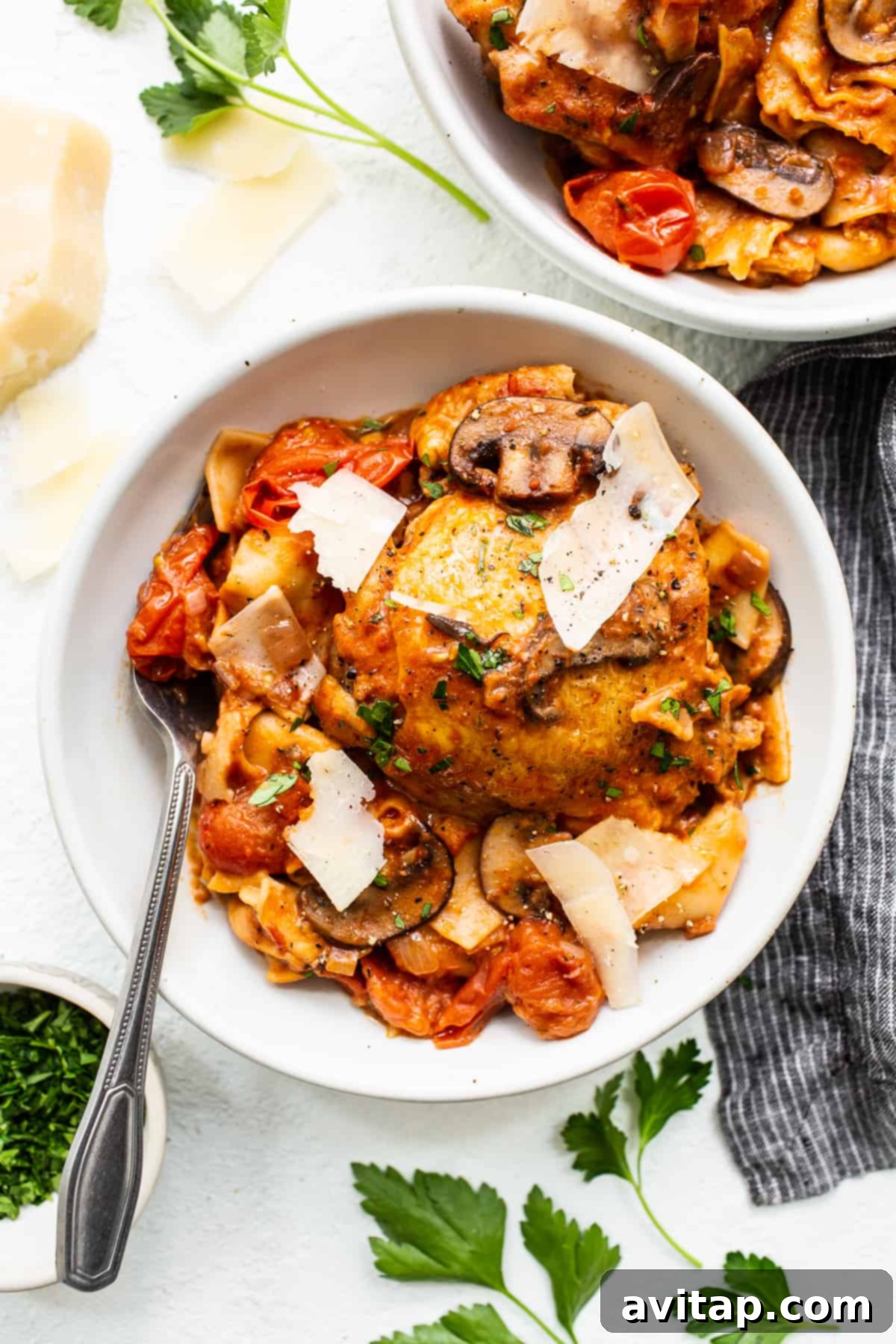 A beautifully plated bowl of one-pot pappardelle pasta with golden-brown chicken thighs, garnished with fresh basil.