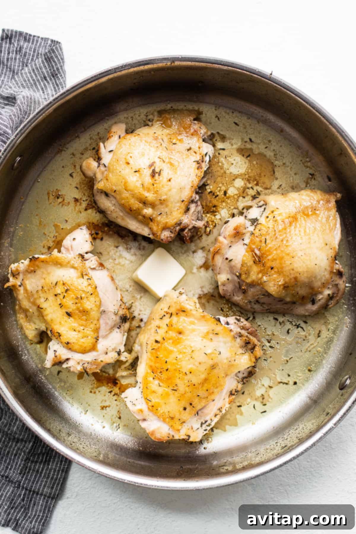Close-up of golden-brown chicken thighs searing in a large skillet, ready to impart rich flavor to the pasta.