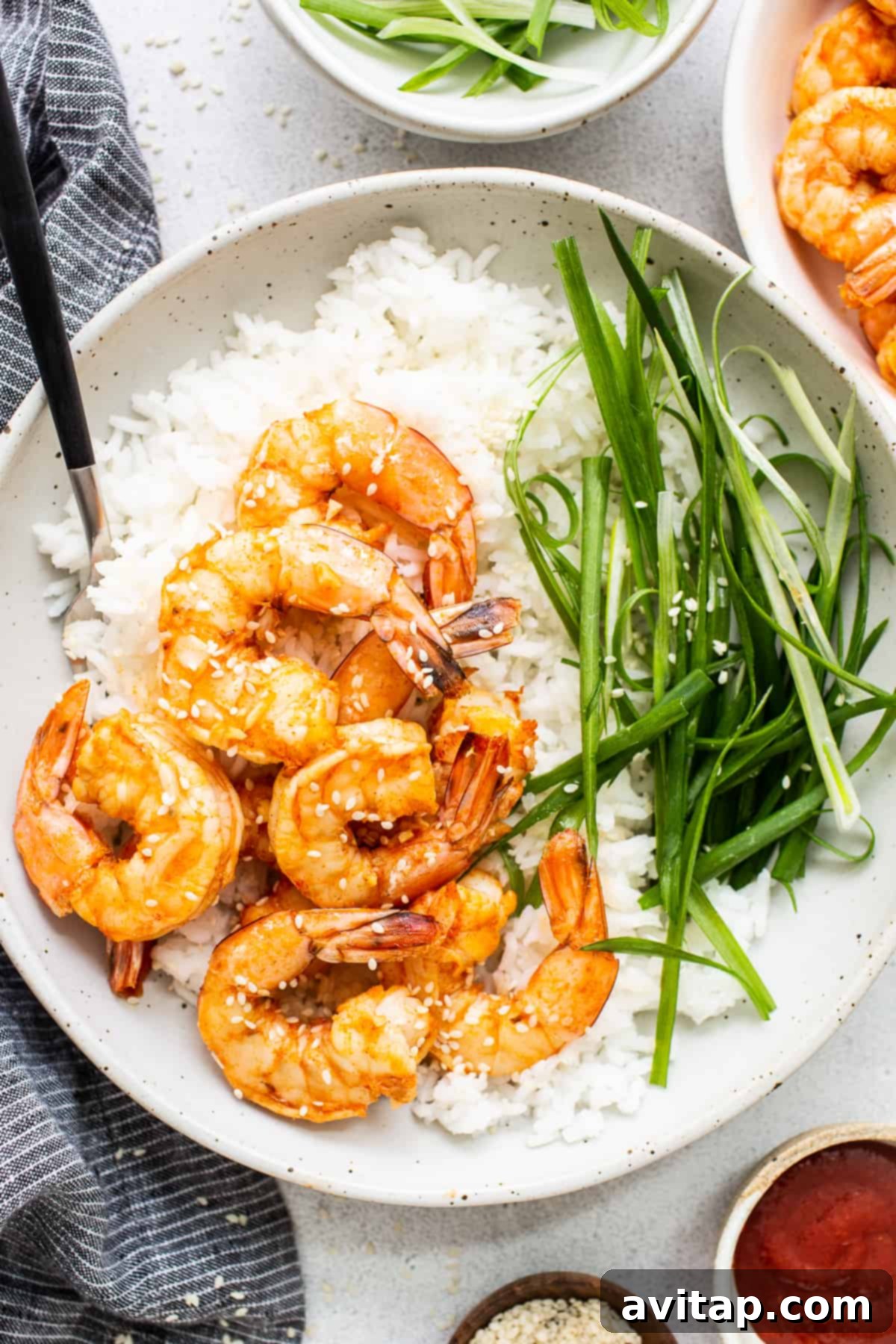 Delicious Spicy Garlic Prawns with Rice Spicy garlic prawns served in a bowl with fluffy white rice, garnished with fresh herbs.
