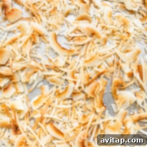 Toasted shredded coconut and flakes evenly spread on a baking pan after being broiled to a perfect golden color.