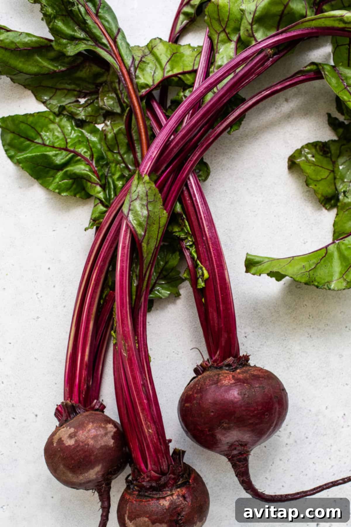 Fresh, whole beets with their green stems attached, signifying freshness.