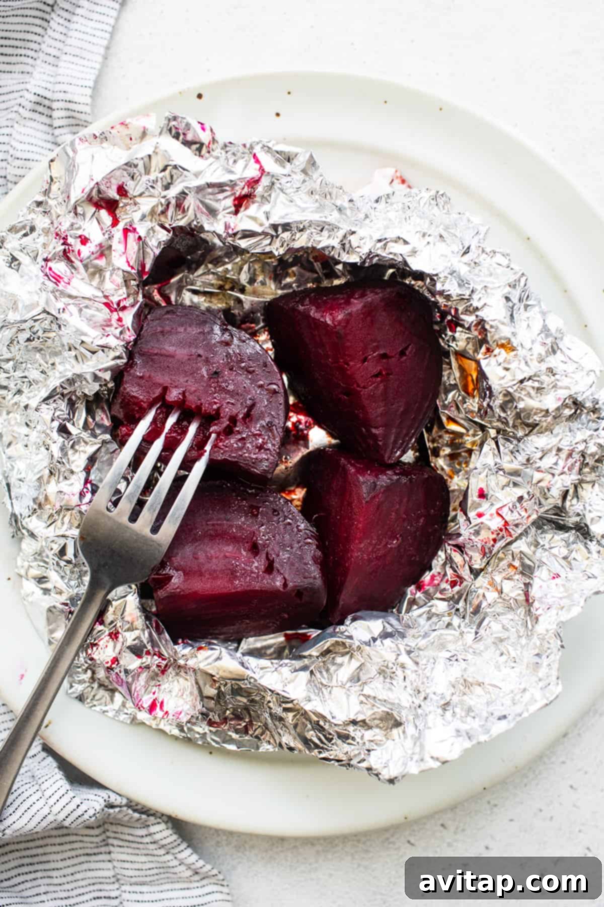 A fork piercing a tender roasted beet piece, showing its soft interior.