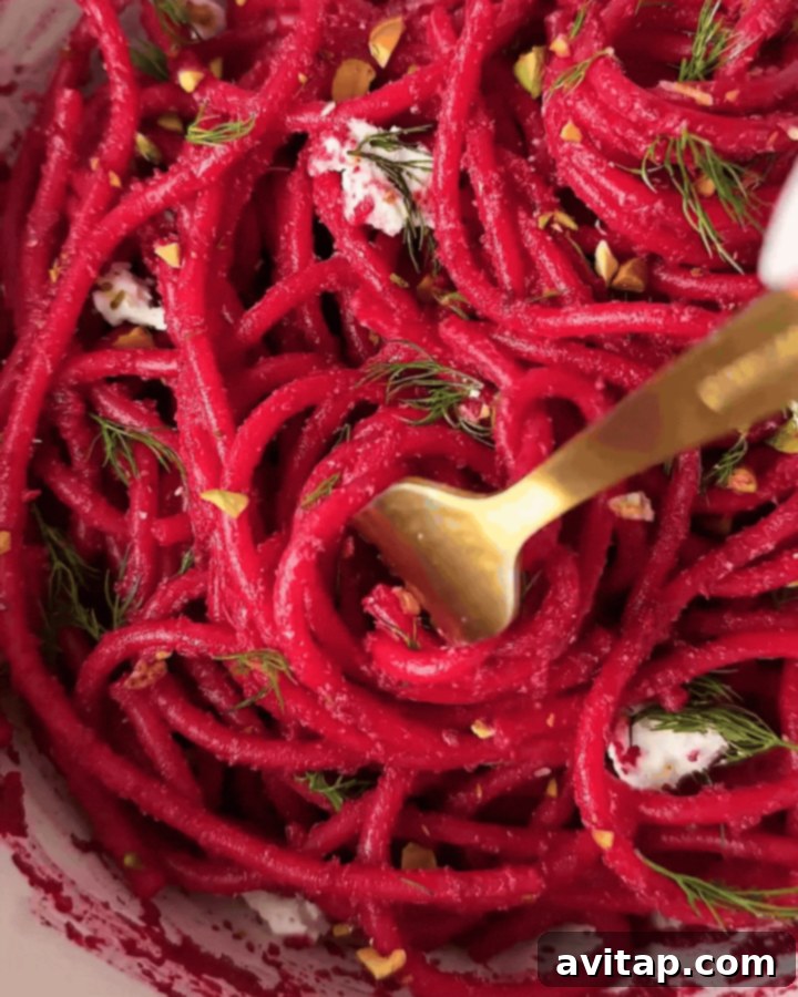 Delicious Roasted Beet Pasta Close-up of a bowl of roasted beet pasta with fresh herbs and a sprinkle of goat cheese, highlighting its rich texture and color.