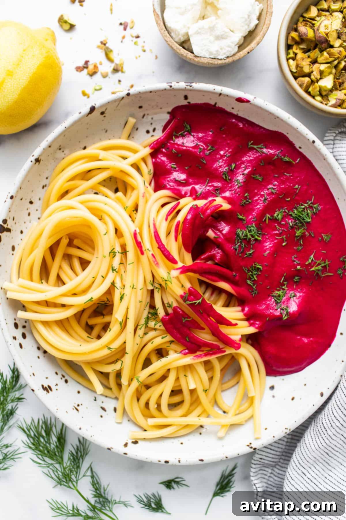Serve Your Homemade Roasted Beet Pasta A bowl of creamy roasted beet pasta, beautifully garnished with fresh dill, goat cheese, and crushed pistachios, ready to be enjoyed.