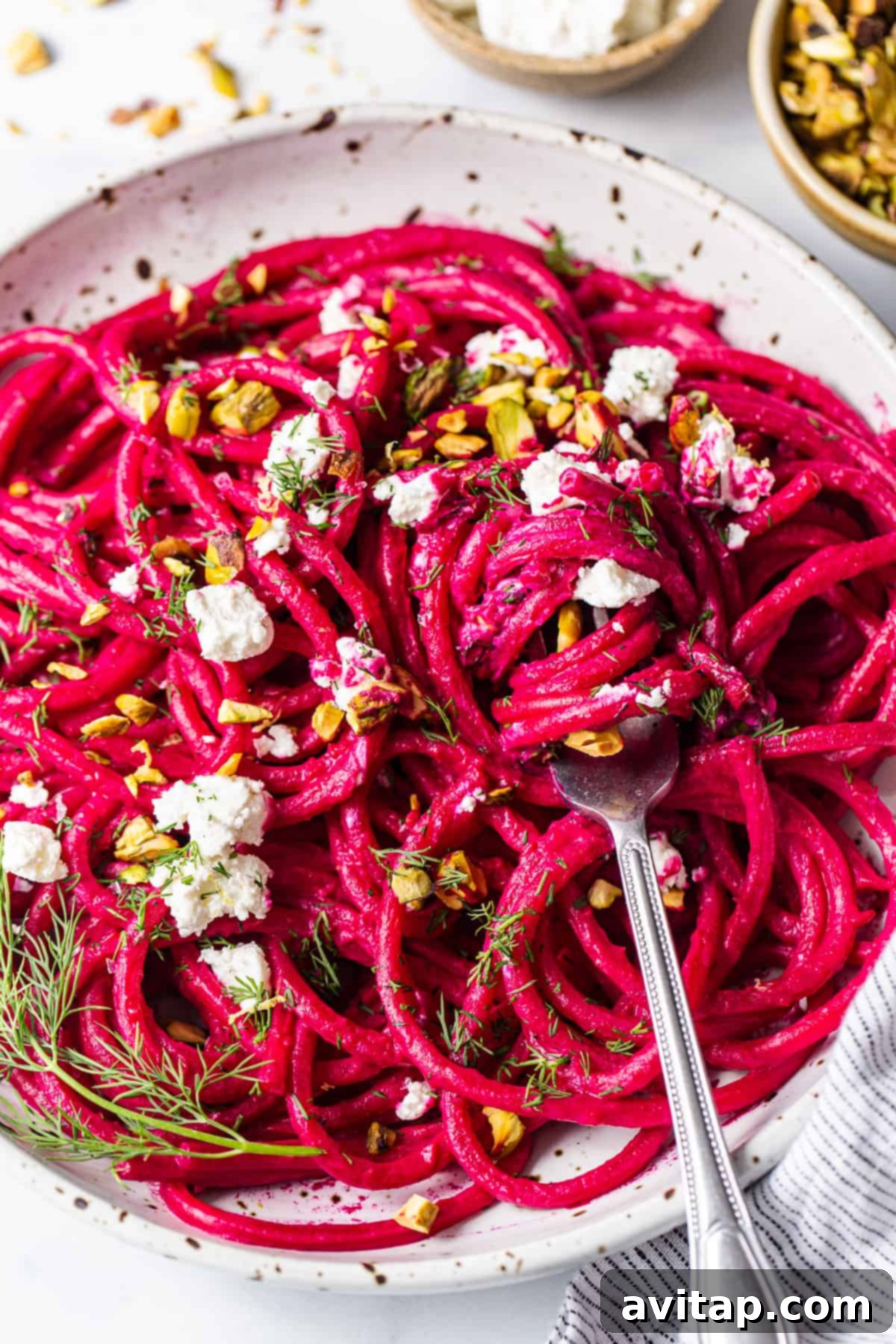 Roasted Beet Pasta with Goat Cheese Topping A close-up of roasted beet pasta in a bowl, generously topped with creamy goat cheese and fresh herbs.