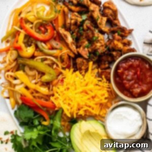 A vibrant platter of freshly cooked sheet pan chicken fajitas, ready to be served with warm tortillas.