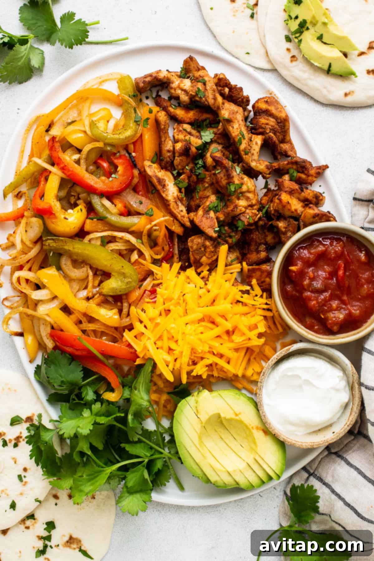 A platter overflowing with cooked sheet pan chicken fajitas, ready to be served.