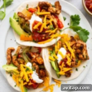 Plated chicken fajitas with toppings.