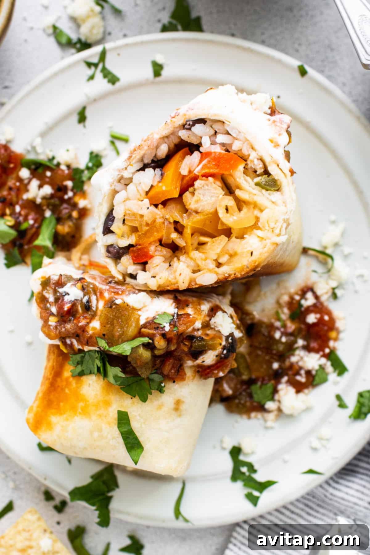 A freshly made chicken fajita burrito served on a plate.