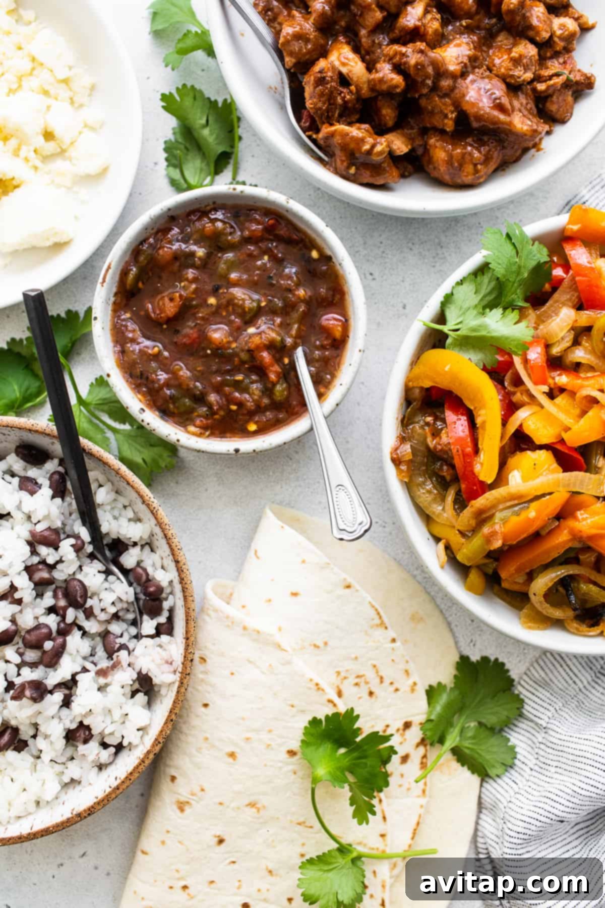 Ingredients for chicken fajita burritos laid out on a kitchen counter.