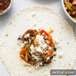 A mexican burrito with peppers and cheese on a plate.