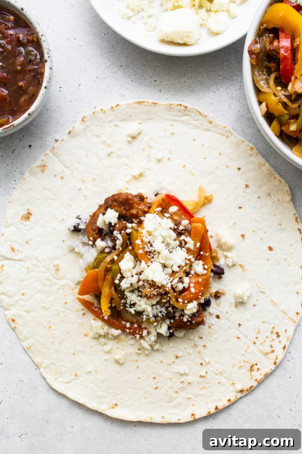 Chicken fajita ingredients carefully arranged on a burrito tortilla.