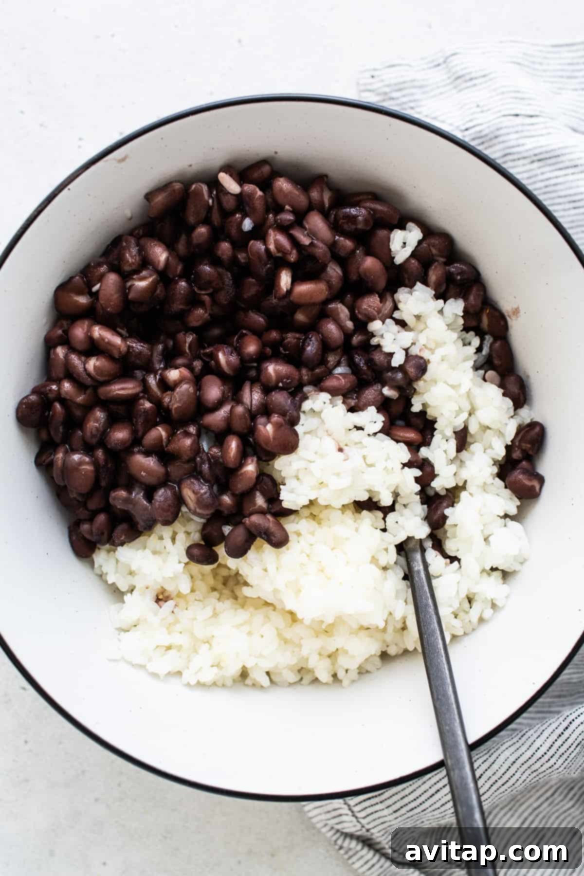 Fluffy rice mixed with black beans in a bowl.