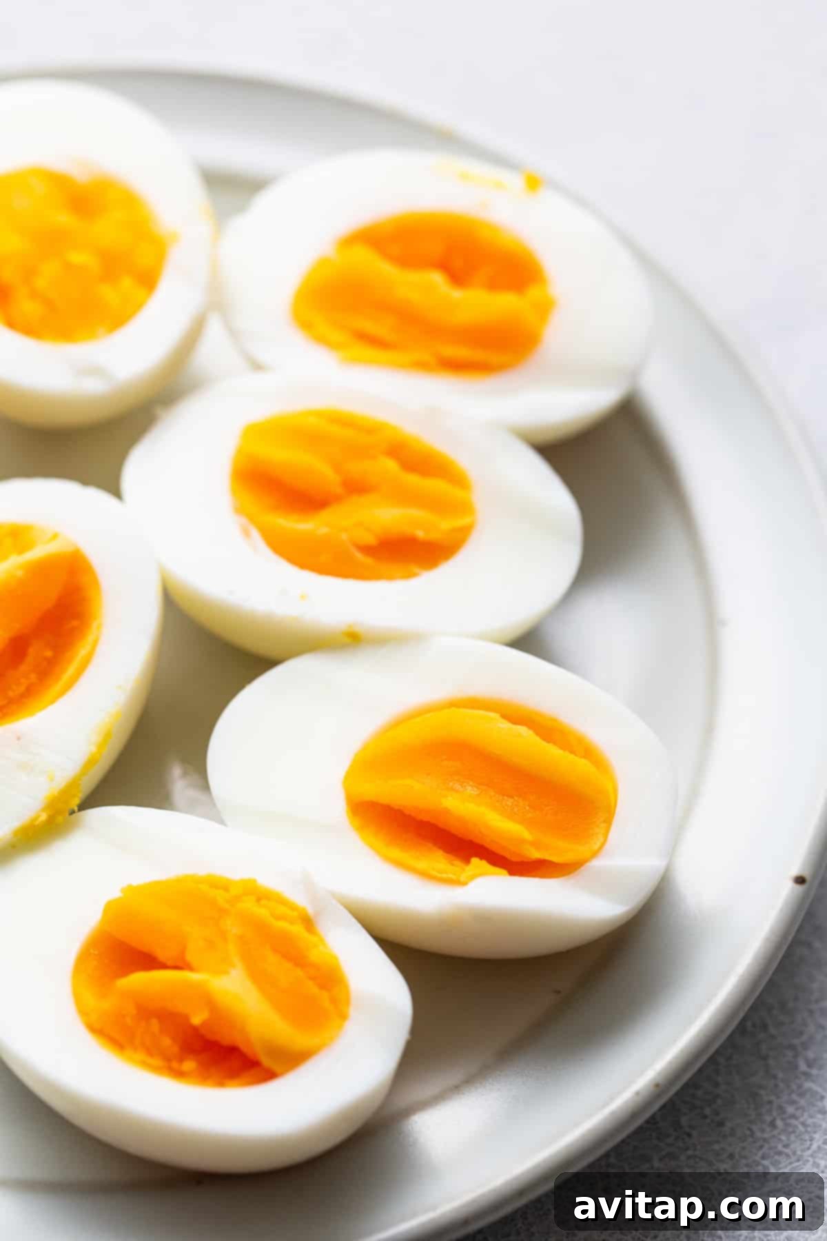 Perfectly cooked air fryer hard boiled eggs on a white plate, ready to be enjoyed.