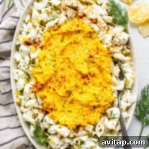 A beautifully presented bowl of creamy deviled egg salad, garnished with a sprinkle of paprika and fresh dill.