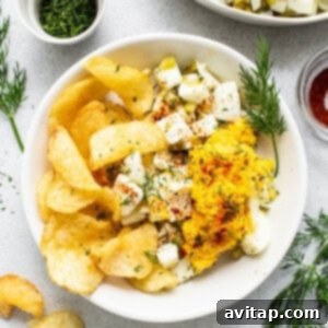 A bowl of potato chips and a bowl of dip.