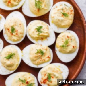 A plate of perfectly prepared deviled eggs, artfully garnished with a sprinkle of paprika and fresh dill sprigs.