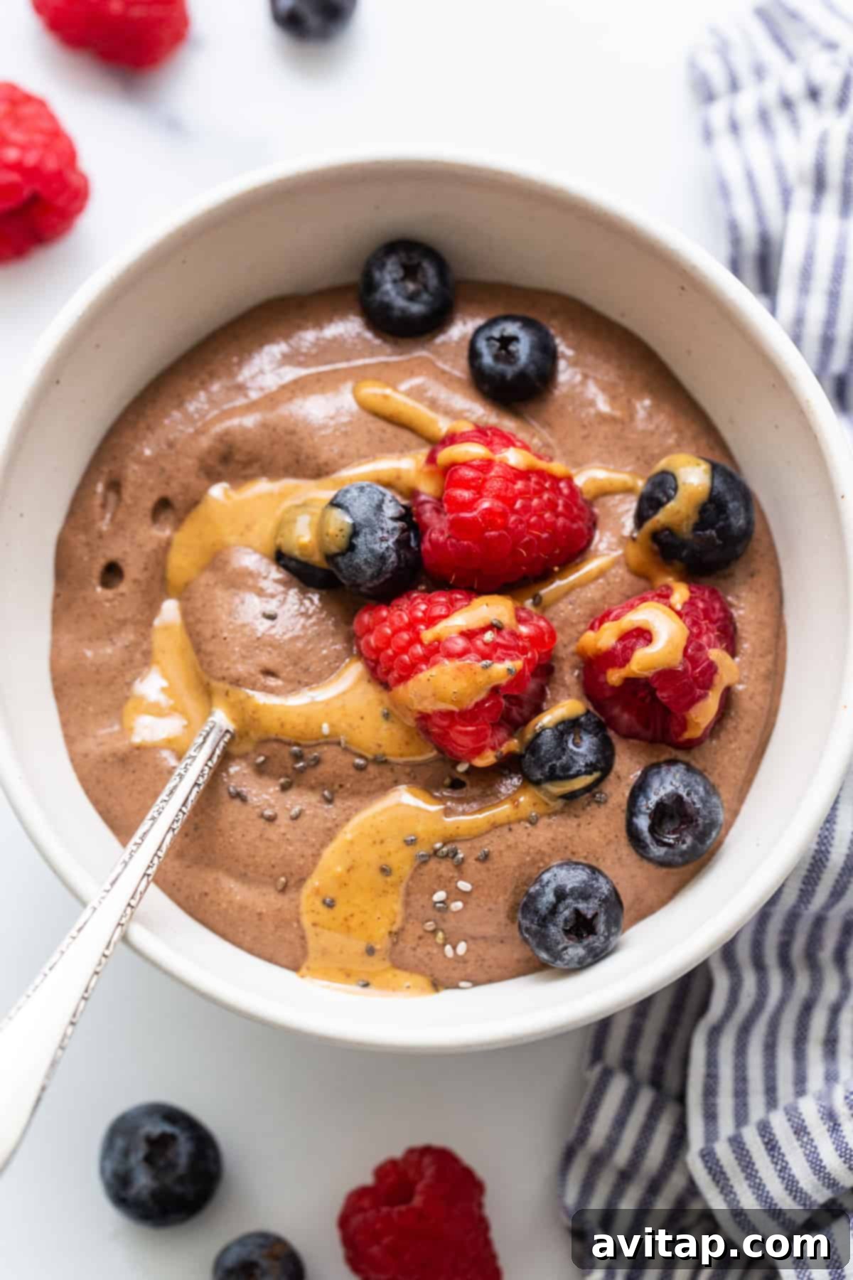 Creamy blended chia seed pudding in a stylish bowl, artfully topped with a swirl of peanut butter and a sprinkle of chocolate shavings.