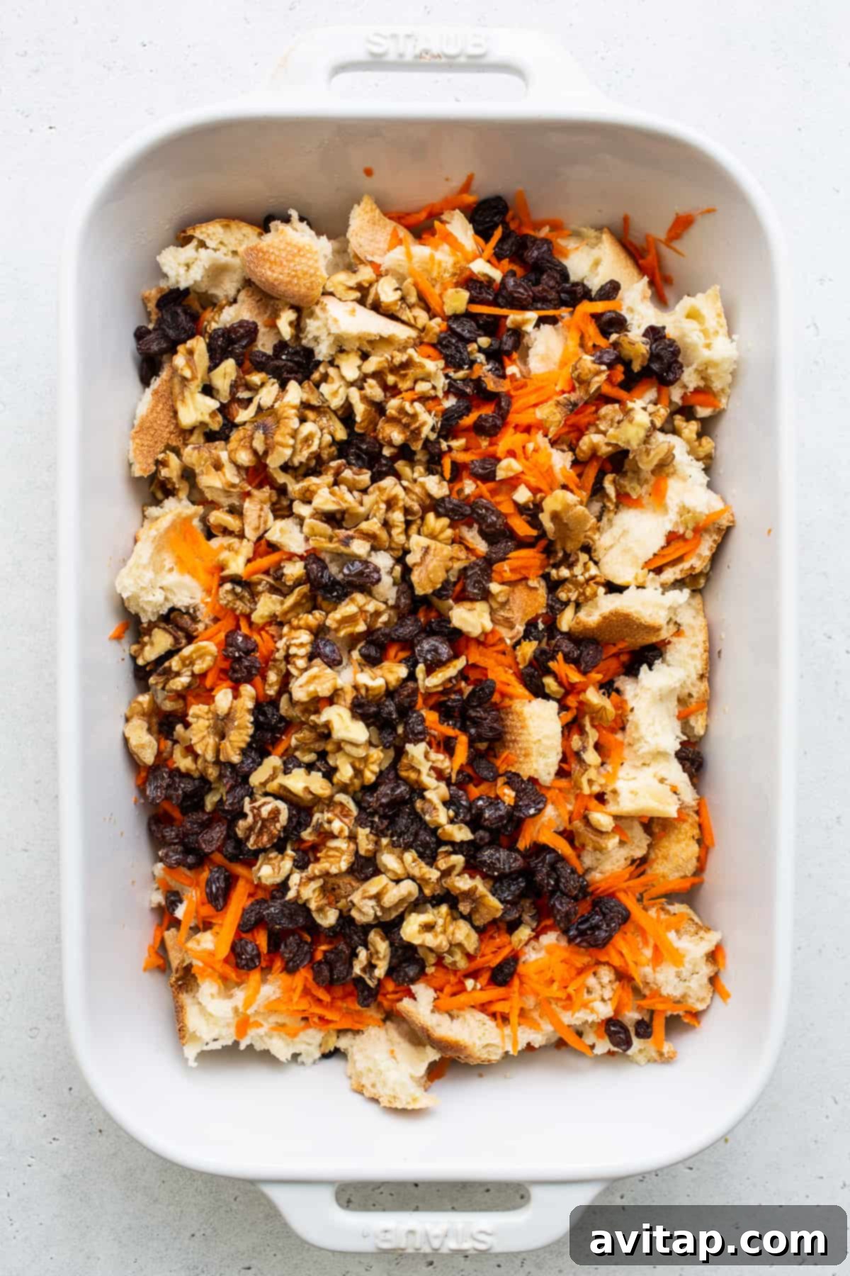 Carrot cake french toast casserole expertly arranged in a casserole dish, ready for baking.