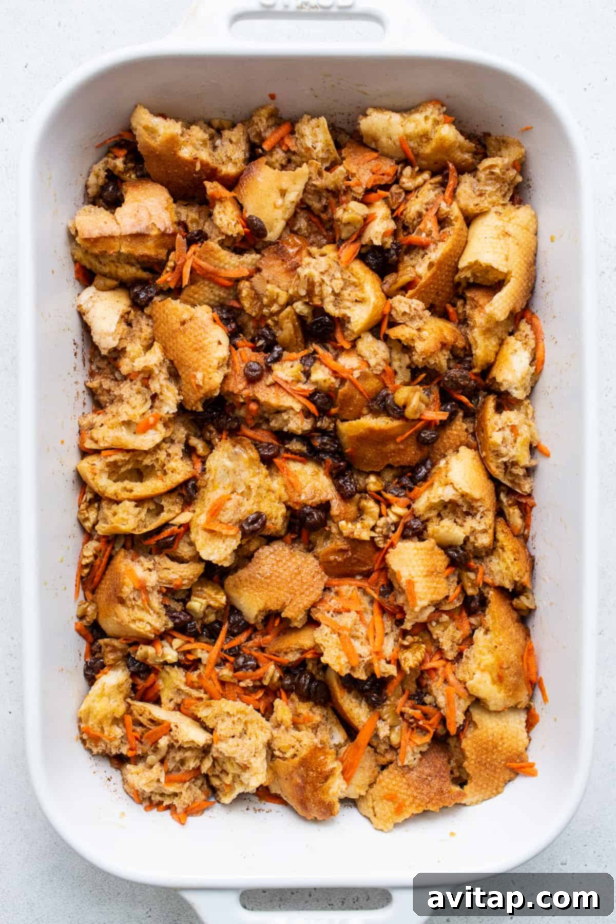 Carrot cake french toast casserole, thoroughly mixed and resting in a casserole dish.