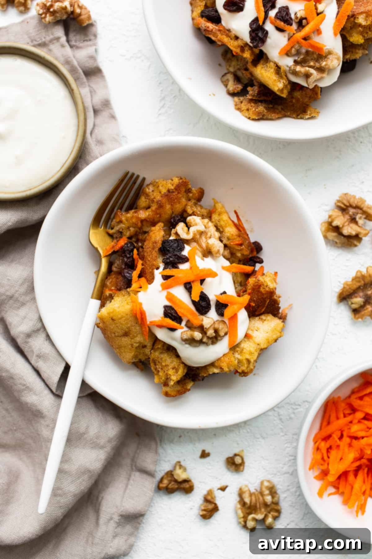 Carrot cake french toast casserole on a plate with a fork, showcasing its delightful texture.
