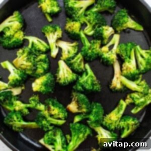 Broccoli florets sautéing in a hot pan.