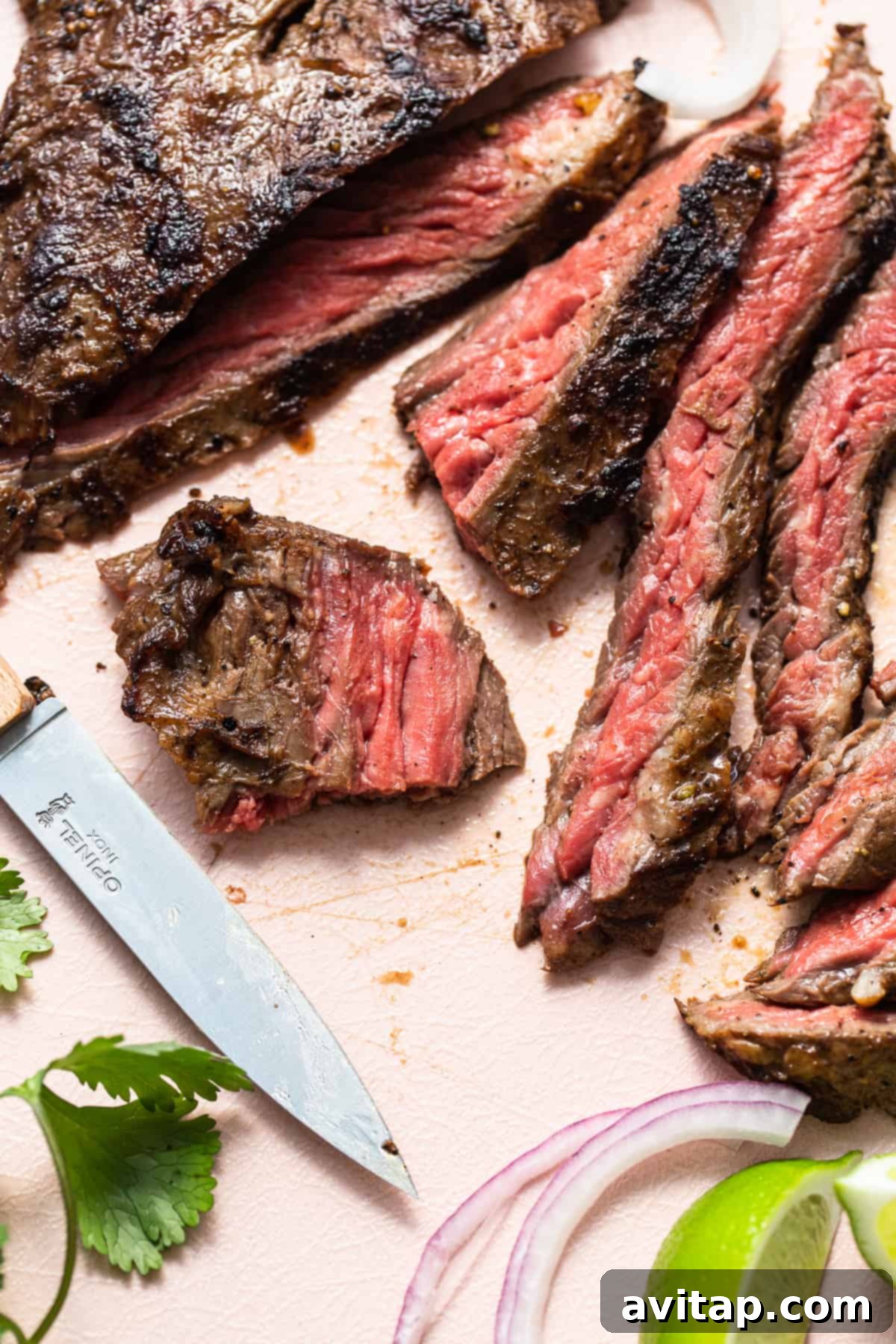 The Perfect Skirt Steak Recipe 7 Slices of skirt steak and a knife on a cutting board.