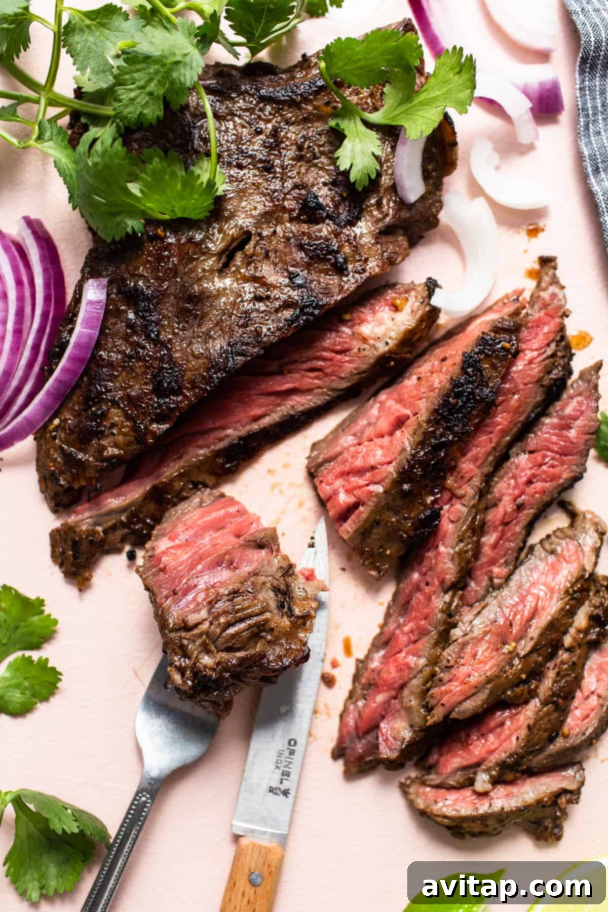 The Perfect Skirt Steak Recipe 8 Sliced skirt steak being cut with a knife, showcasing its tender texture.