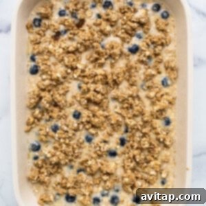 Blueberry oatmeal in a white baking dish, topped with streusel and ready to bake.