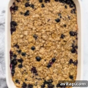 Freshly baked blueberry oatmeal in a white baking dish, cooling down.