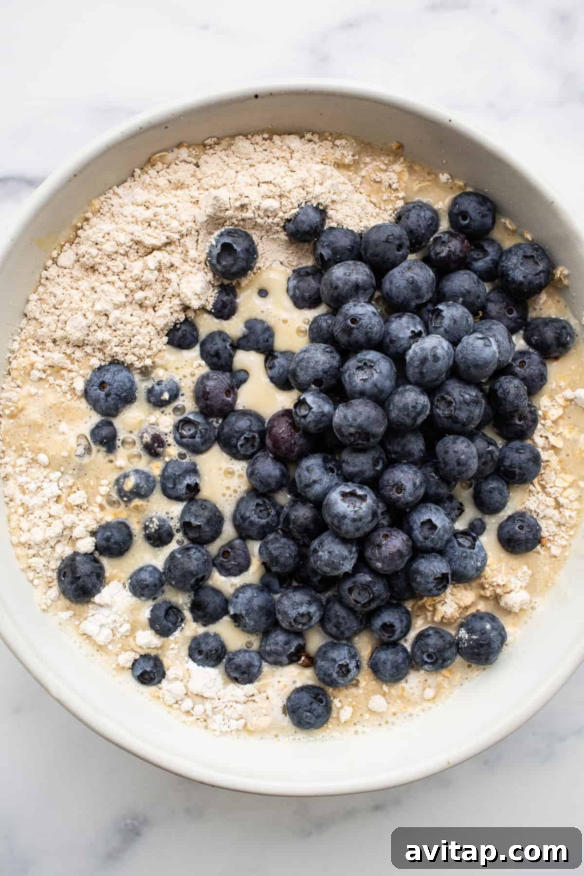 Blueberry muffin baked oatmeal batter in a bowl, ready for baking.