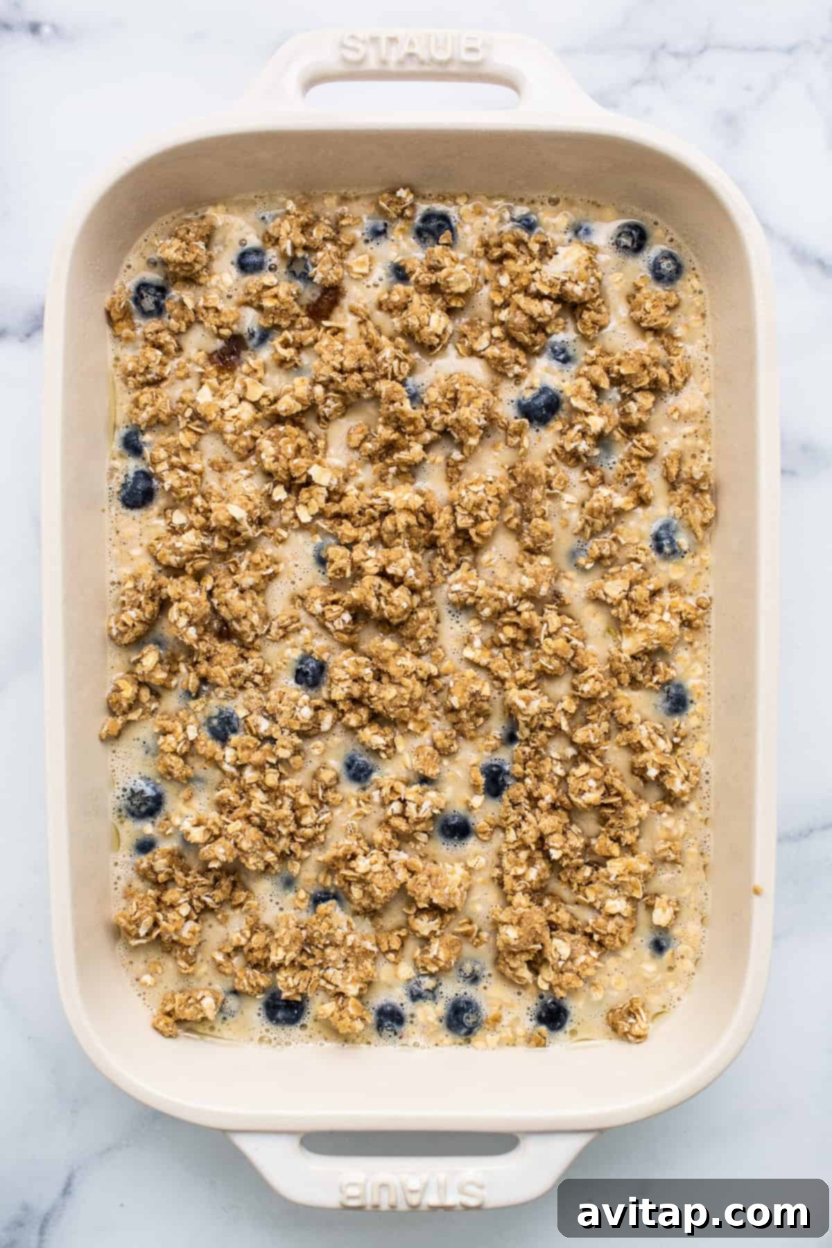 Blueberry muffin baked oatmeal batter with a streusel topping, ready for the oven.