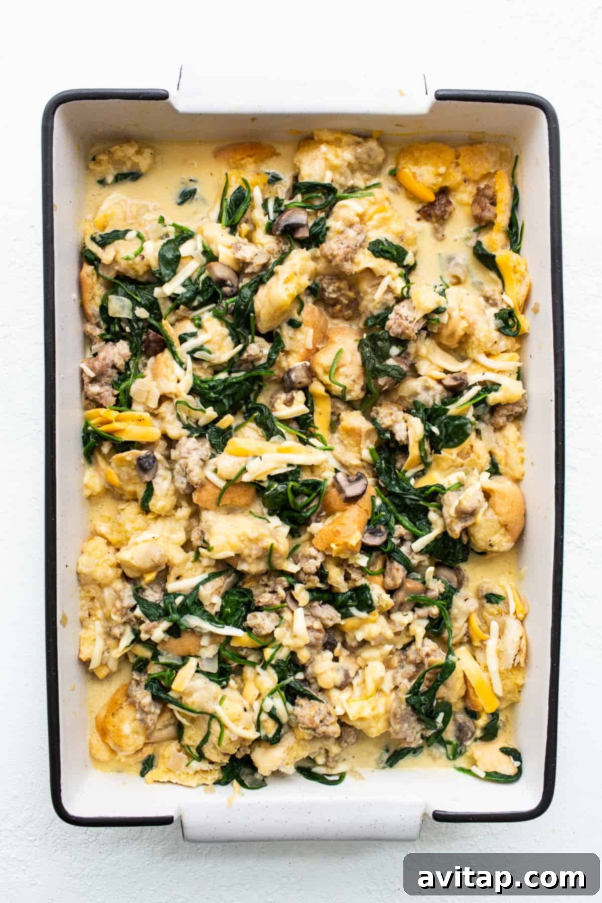 Breakfast strata beautifully soaking overnight in a casserole dish, ready for baking the next morning.