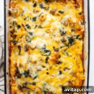 A baked casserole with spinach and golden-brown cheese in a baking dish.