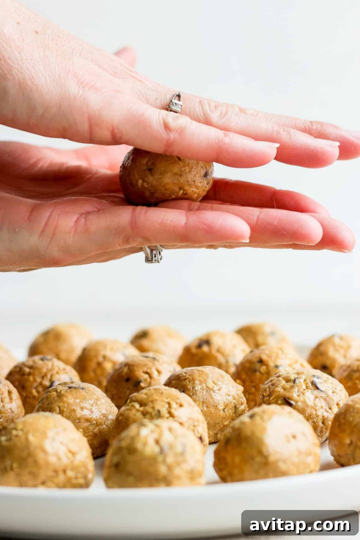 Hands rolling a collagen cookie dough ball, showcasing the perfect consistency.