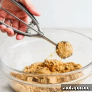 Hands rolling dough into cookie dough balls.