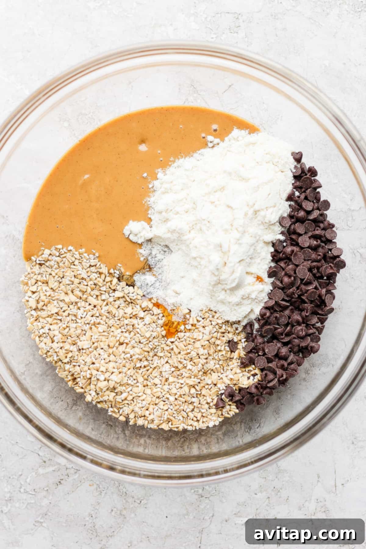 Ingredients for healthy collagen cookie dough laid out in a mixing bowl before combining.