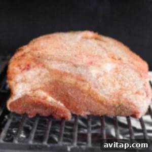 Ham cooking in a smoker, absorbing smoke flavor.