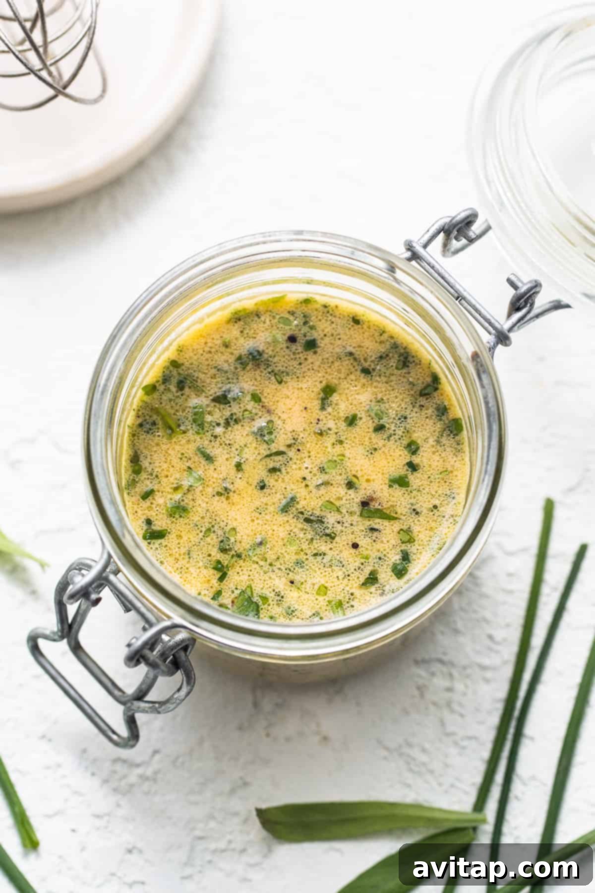 Hummus dressing in a glass jar, showcasing its vibrant herby texture.