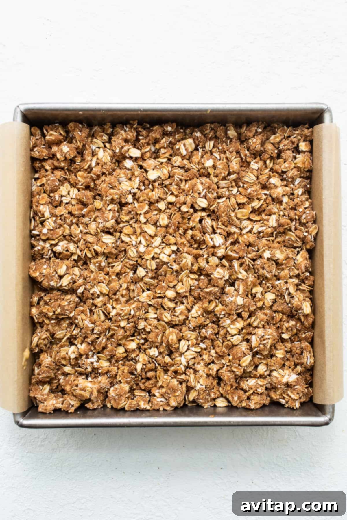 Streusel topping evenly spread over the coffee cake batter in a baking pan.