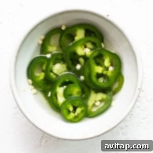 Fiesta Street Corn Chicken Salad 3 Thinly sliced jalapeños marinating in a pickling liquid in a small clear glass bowl.