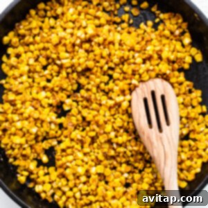 Fiesta Street Corn Chicken Salad 5 Corn kernels actively cooking and charring in a hot frying pan, creating a smoky aroma and caramelized flavor.