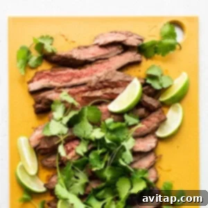 Ultimate Steak Fajita Marinade 8 Perfectly sliced marinated steak on a wooden cutting board, ready to serve.