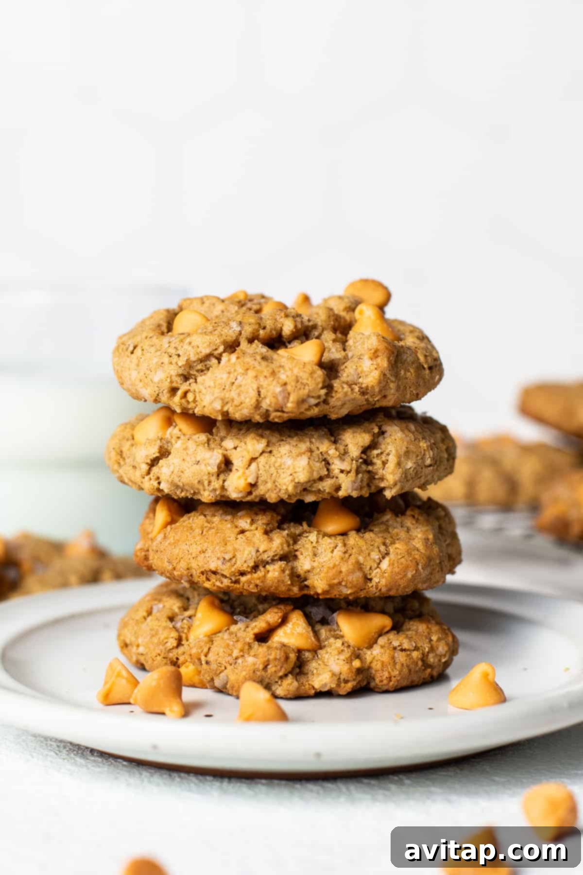 Stack of four perfectly baked flourless brown butter oatmeal butterscotch cookies on a small white plate, ready to be enjoyed.