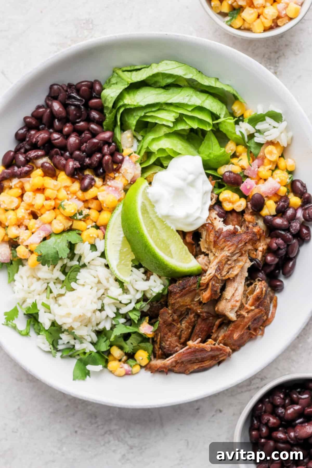 Delicious and healthy Slow Cooker Carnitas Burrito Bowls in a glass container, ready for meal prep.