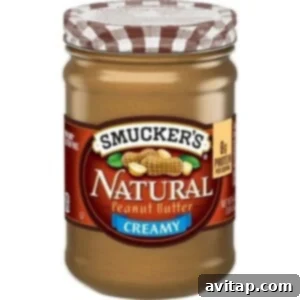 Jar of natural peanut butter on a clear background, our favorite choice for recipes