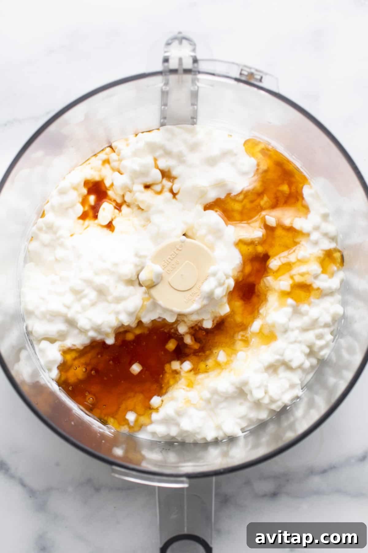 A high-speed blender containing creamy cottage cheese, ready to be processed for homemade ice cream.