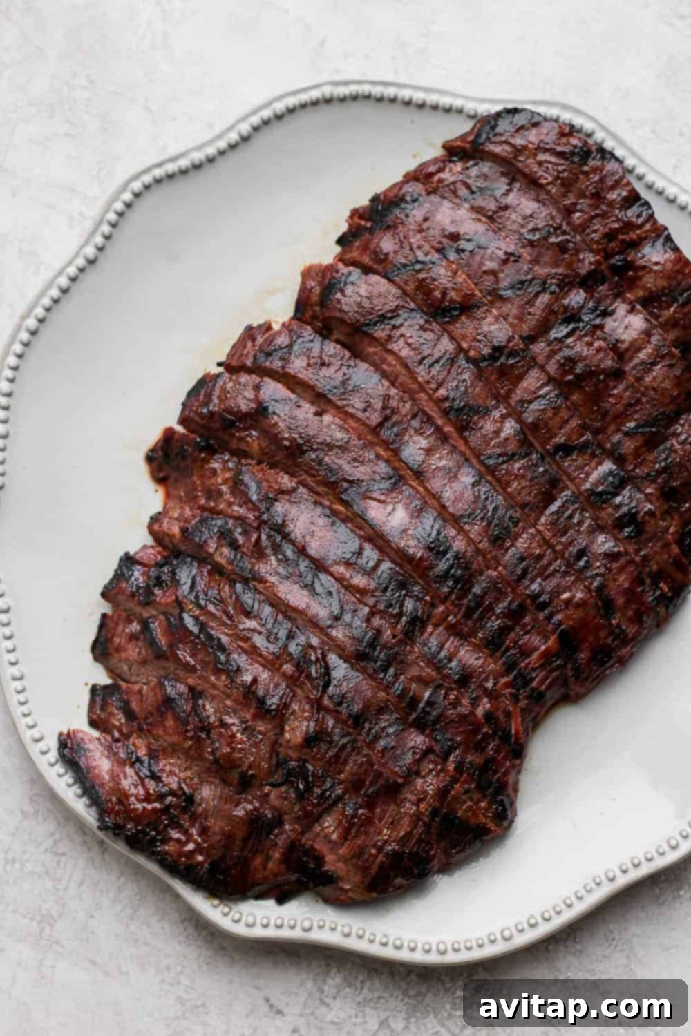 Perfectly sliced, tender flank steak presented beautifully on a plate, ready to be enjoyed.